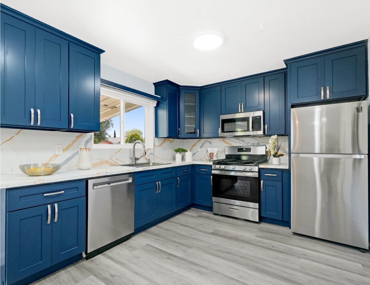 ADU kitchen with blue cabinetry and marble backsplash