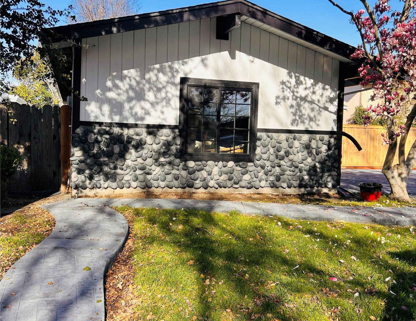 Exterior after — new board and batten siding with stone veneer